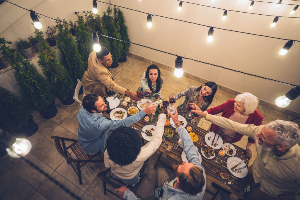 Eine Familie genießt gemeinsam ein festliches Dinner an einem liebevoll gedeckten Tisch und stößt mit Wein an