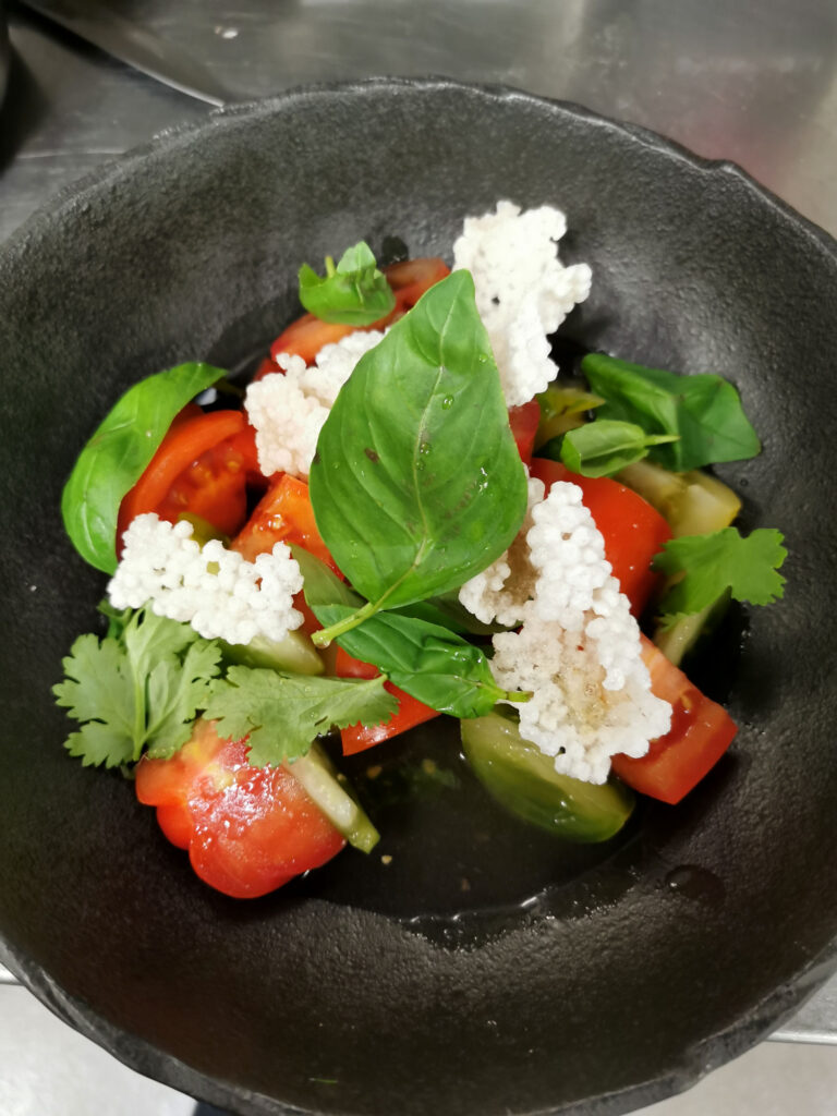 Tomatensalat mit Kräuter in einer schwarzen Schüssel