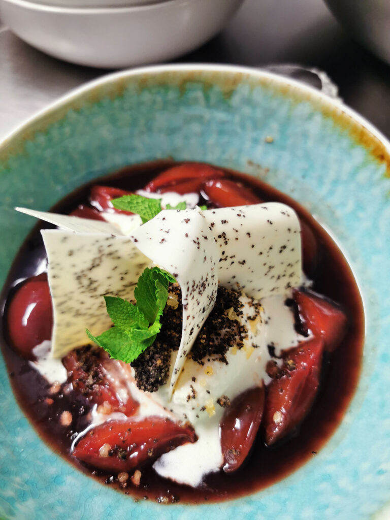 Dessert mit Zwetschgen, Vanillecreme, weißer Schokolade, Schokoladencrumble und frischer Minze.